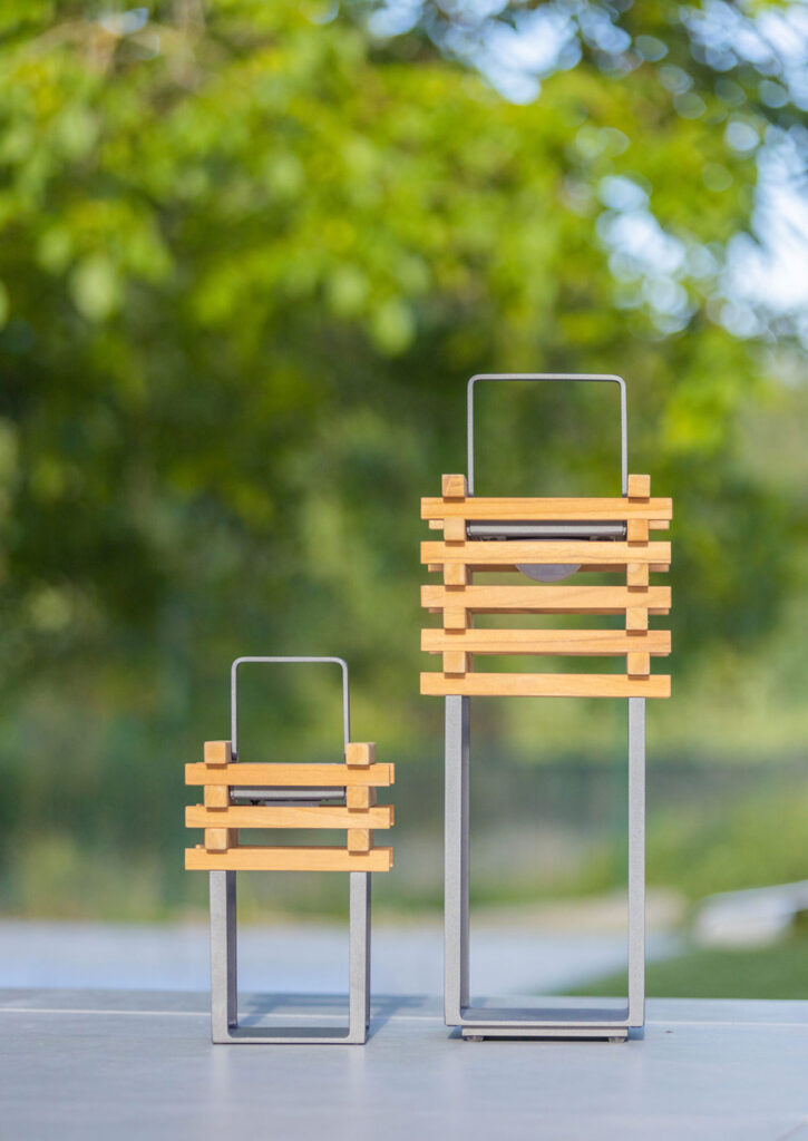 TEAK Solarlampe, 3 Stück STAY lamp tragbare Design-Außenleuchte Solarbetrieb aufladbar über USB-Anschluss dimmbar 30 – 50 – 100% Nutzung im Außenbereich (LxBxH) 230mm x 230mm x 550mm Inhalt: 3 Stück (Mindestabnahme) TEAK Solarlampe, 3 Stück: Entdecken Sie die perfekte Beleuchtungslösung für Ihren Außenbereich mit unserer tragbaren Leuchte, die aus einem robusten Aluminium-Rahmen und einem eleganten Lampenkörper aus Teakholz gefertigt ist. Diese vielseitige Solarlampe ist nicht nur ein optisches Highlight, sondern auch extrem funktional. Sie kann einfach getragen, auf den Boden gestellt oder aufgehängt werden und ist auch in einer kleineren Version als Tischleuchte erhältlich. Dank ihres modernen Designs und der hochwertigen Materialien ist diese Leuchte ideal für den dauerhaften Einsatz im Freien geeignet. Der Aluminium-Rahmen bietet hervorragende Wetterbeständigkeit und Korrosionsschutz, während das Teakholz durch seine natürliche Widerstandsfähigkeit und Langlebigkeit überzeugt. Diese Kombination sorgt für eine stilvolle und langlebige Beleuchtungslösung. Betrieben über Solarenergie oder USB, bietet diese Leuchte eine umweltfreundliche und flexible Beleuchtungsoption. Tagsüber lädt sich der integrierte Akku durch Sonnenlicht auf, und bei Bedarf kann die Lampe auch bequem über USB aufgeladen werden. Dies stellt sicher, dass Sie immer eine zuverlässige Lichtquelle zur Verfügung haben, egal ob im Garten, auf der Terrasse oder beim Camping. Die tragbare Leuchte aus Aluminium und Teakholz fügt sich harmonisch in jede Outdoor-Umgebung ein und schafft eine einladende Atmosphäre. Ob als Bodenleuchte, Hängelampe oder Tischleuchte – sie bietet vielfältige Einsatzmöglichkeiten und passt sich Ihren individuellen Bedürfnissen an. Investieren Sie in Qualität und Stil mit unserer tragbaren Solarlampe, die durch ihre Ästhetik und Funktionalität überzeugt. Verleihen Sie Ihrem Außenbereich einen Hauch von Eleganz und Nachhaltigkeit mit dieser vielseitigen Beleuchtungslösung.